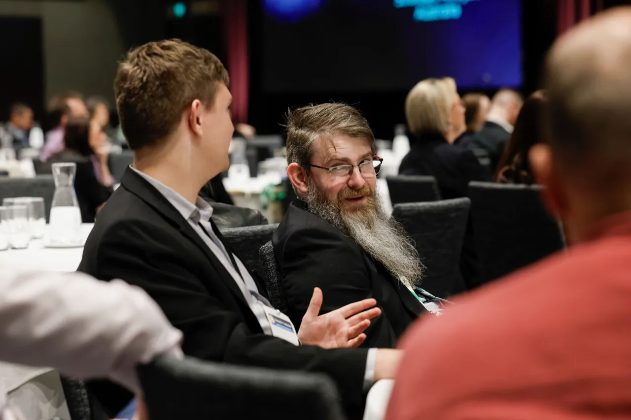 Delegates seated around a conference table in conversation at AIPIO Intelligence 2026.